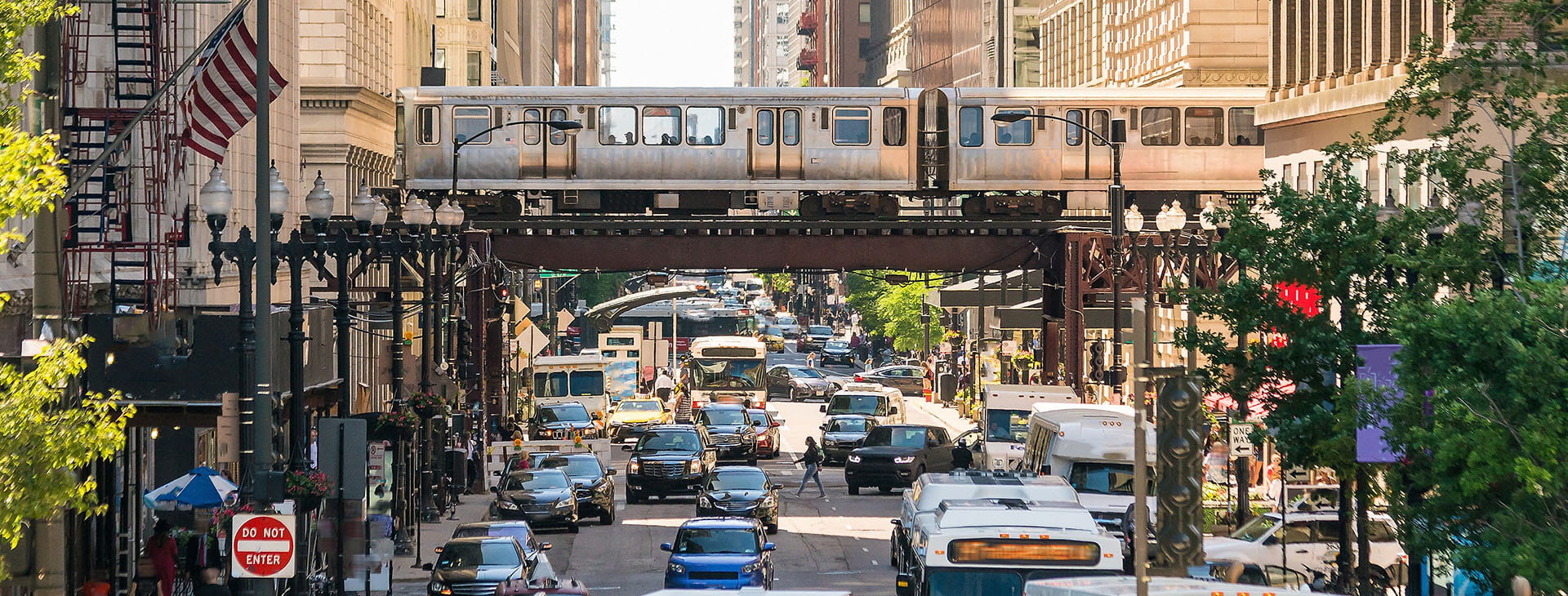 train track over street with traffic in chicago