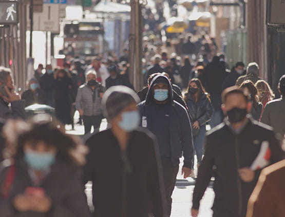 people walking on sidewalk with medical masks on