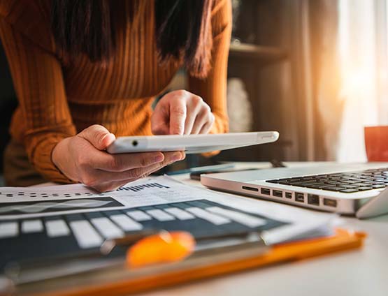 Businesswoman working on digital marketing media in and office with mobile phone and laptop