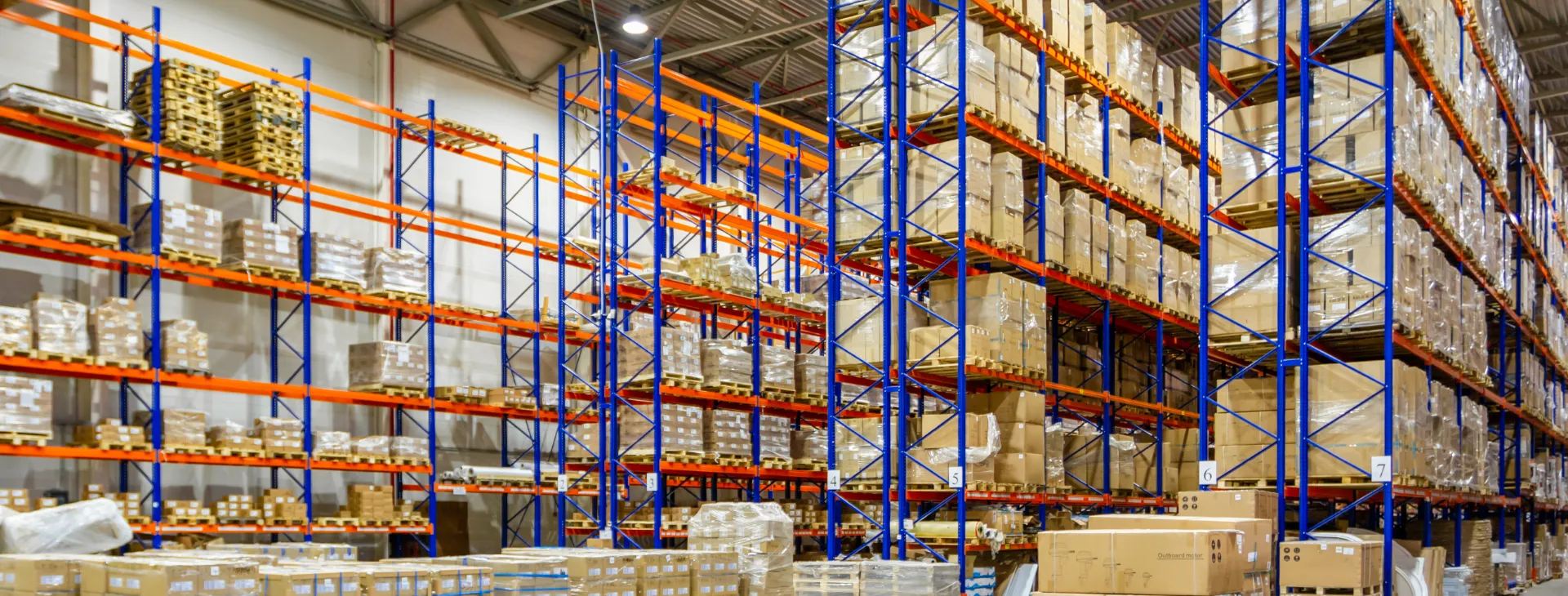 Interior of a modern warehouse storage of retail shop with pallet truck near shelves