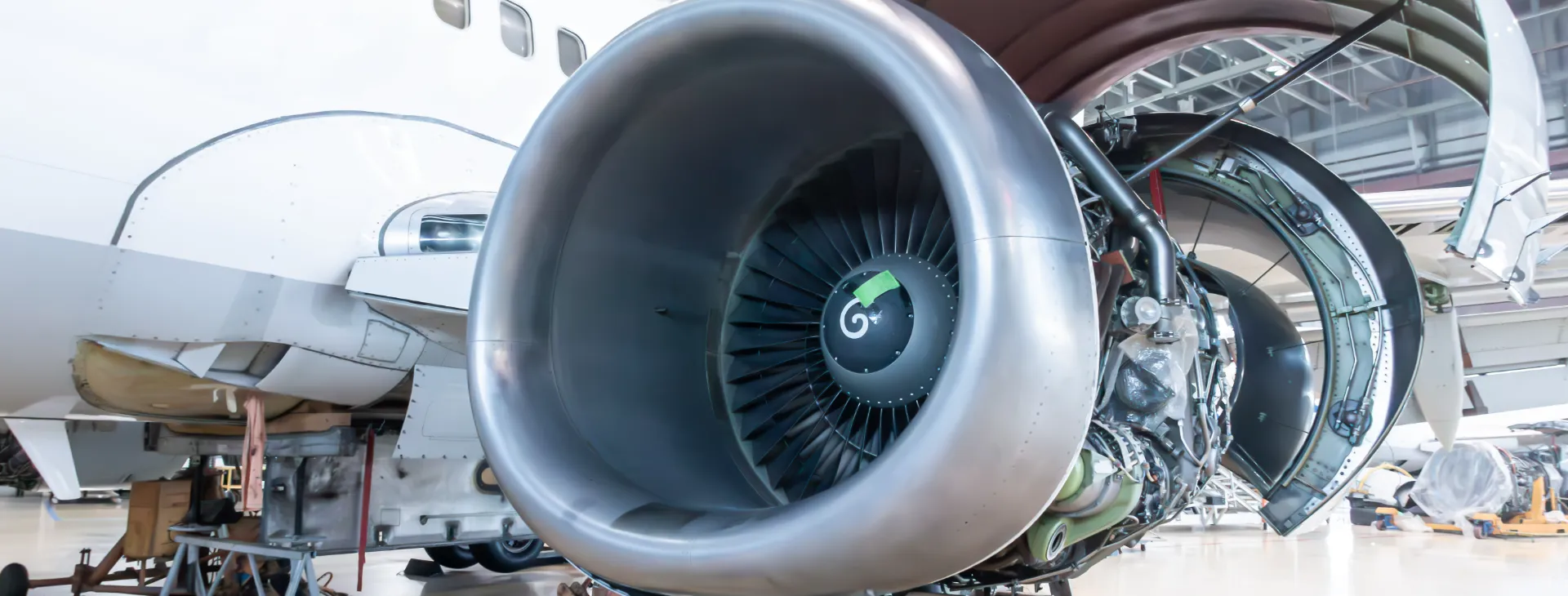 Close-up of an open high bypass turbofan aircraft engine of a passenger airliner in airplane hangar