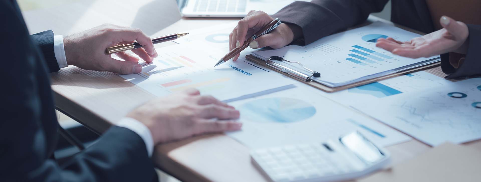 two business professionals reviewing financial reports