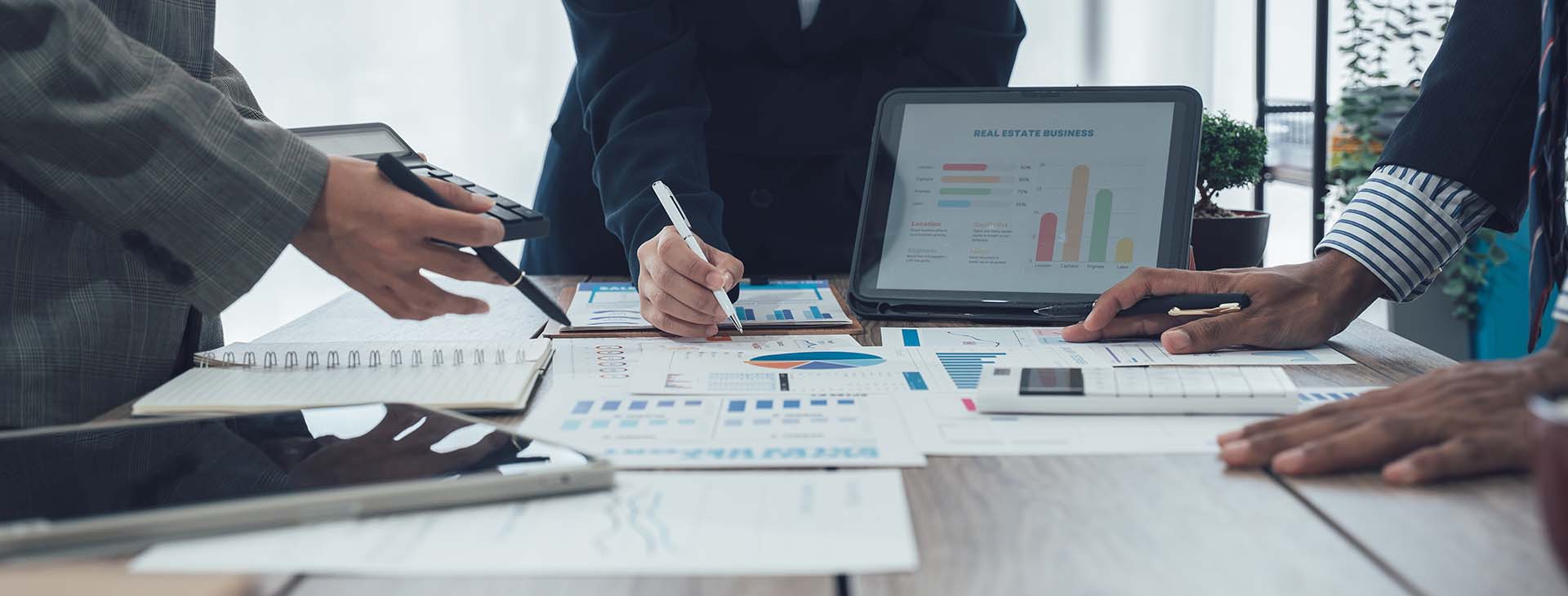 business professionals reviewing financial reports around a conference room table