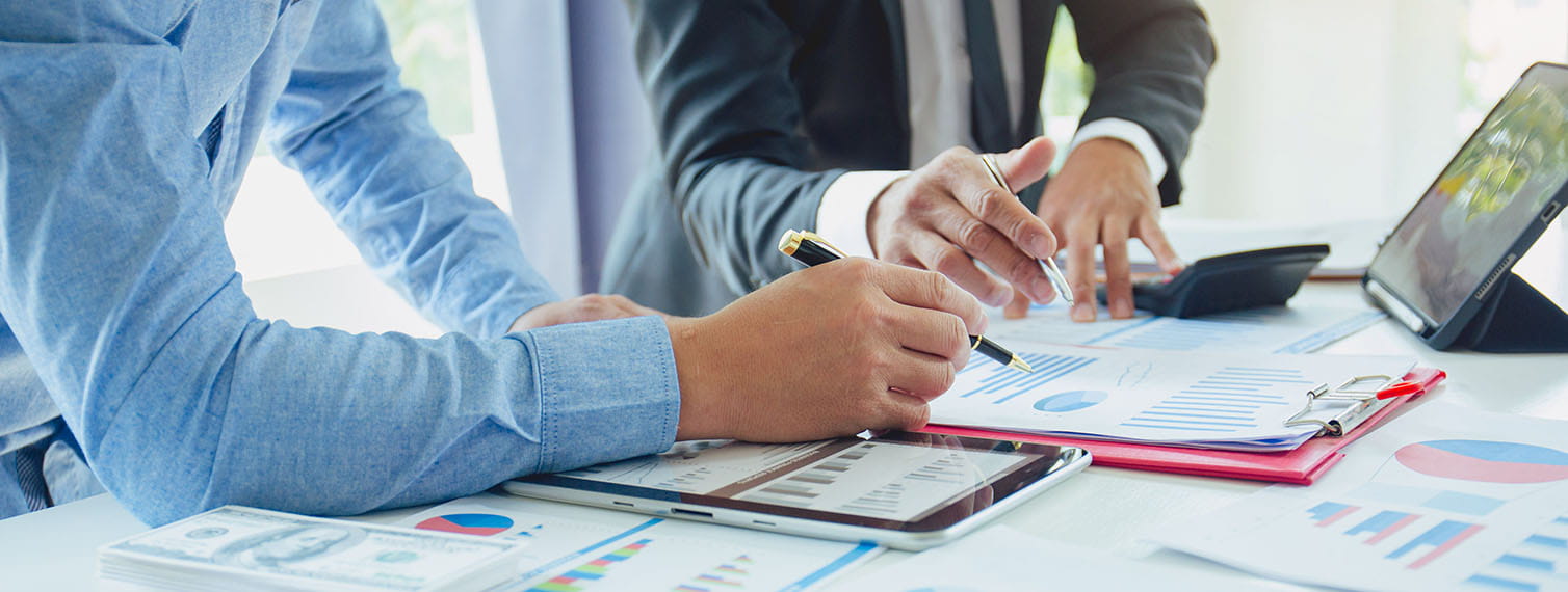 Business people analyzing financial reports and graphs