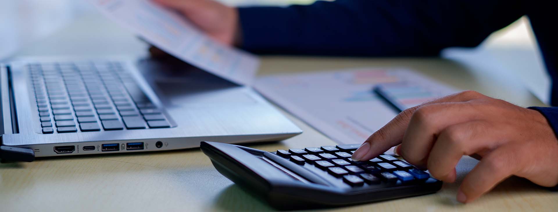 businessman working at a desk on a computer reviewing a graph