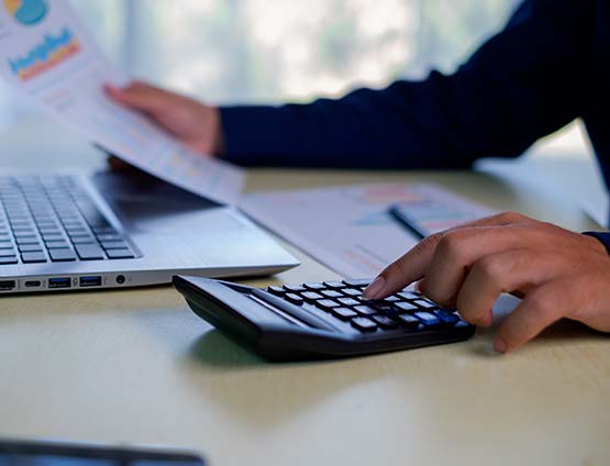 businessman working at a desk on a computer reviewing a graph