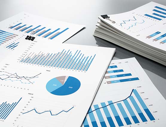 Piles of financial reports with graphs and charts