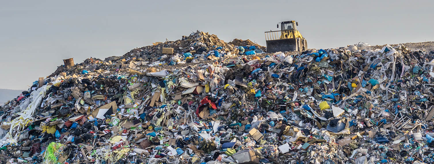 landfill with tractor on top of hill