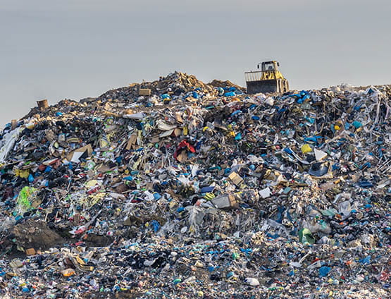 landfill with tractor on top of hill