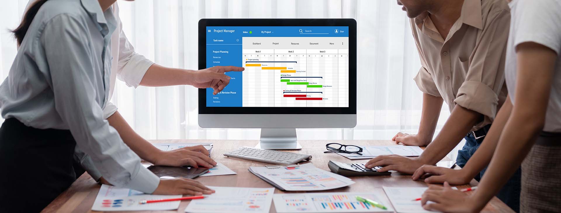 team looking at project management software on a computer screen