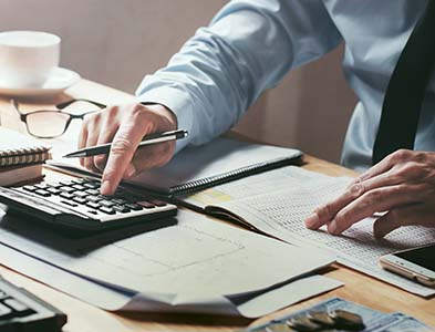businessman working on desk office with using a calculator to calculate numbers
