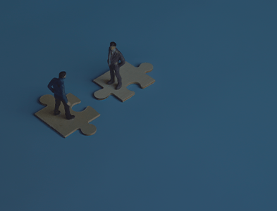 Two men standing on puzzle pieces