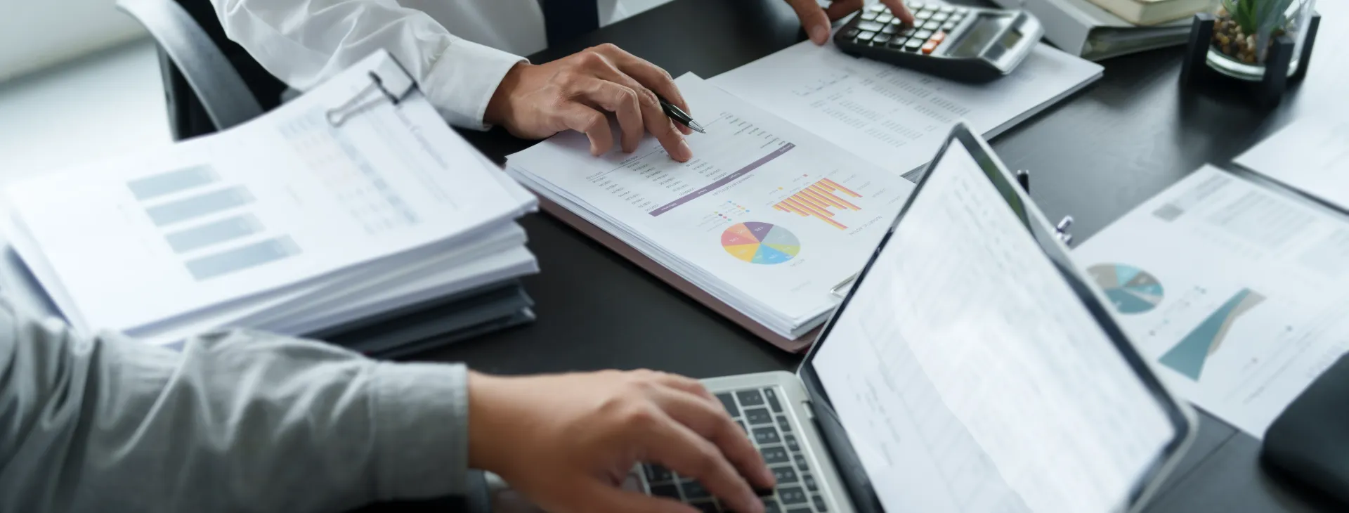 Businessman analyzing data paperwork calculating numbers.