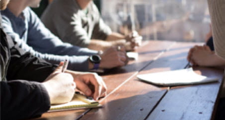Team sitting at a table with notebooks